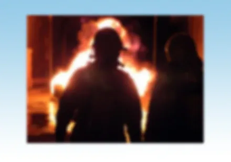 Silueta de una persona recortada contra las llamas durante un simulacro de incendio